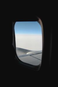 Aile d'avion et nuages vus à travers le hublot