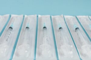 Seringues stériles emballées alignées sur un fond bleu